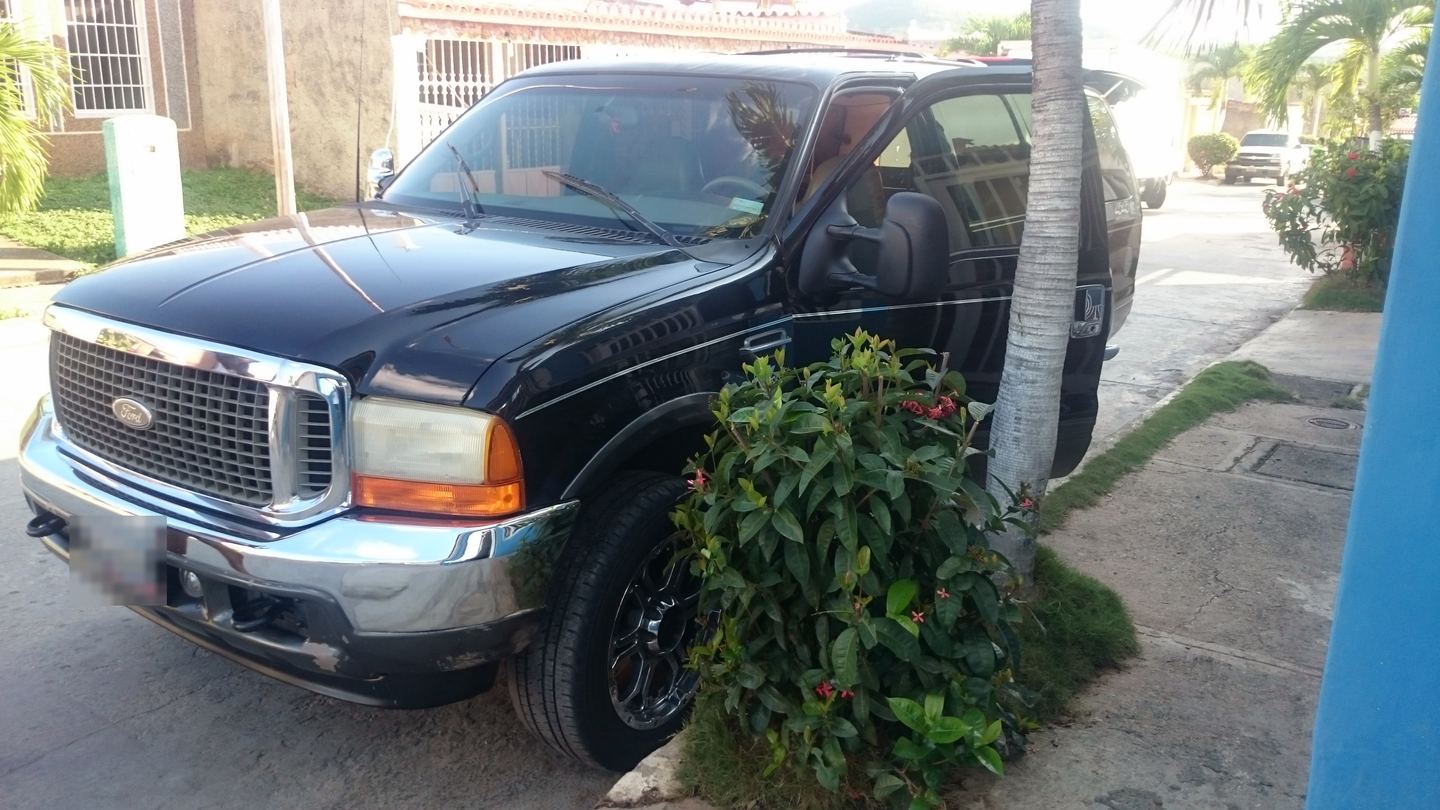 La Ford Excursion negra vista de frente, estacionada en una calle.