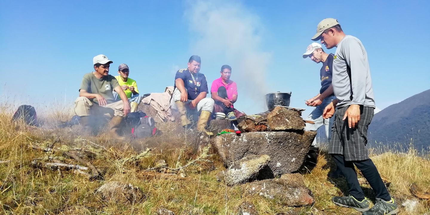 El grupo alrededor de un fogón humeante en lo alto de la loma.