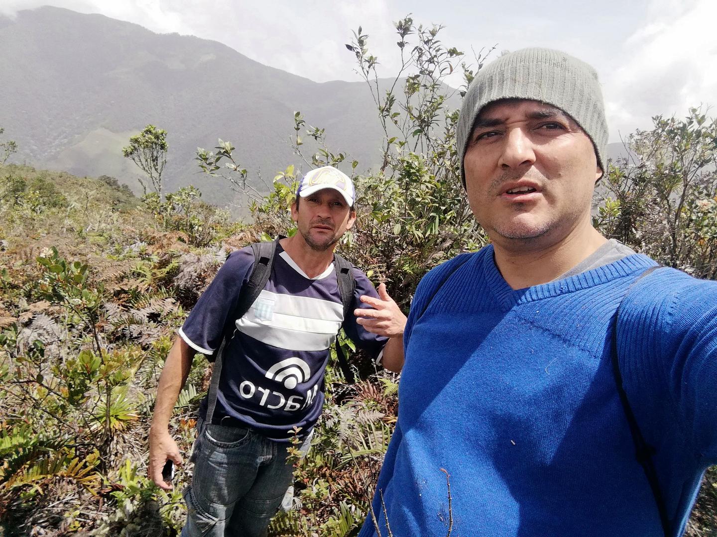 Freddy, con gorro gris y suéter azul, y Jairo detrás, entre la vegetación del páramo.