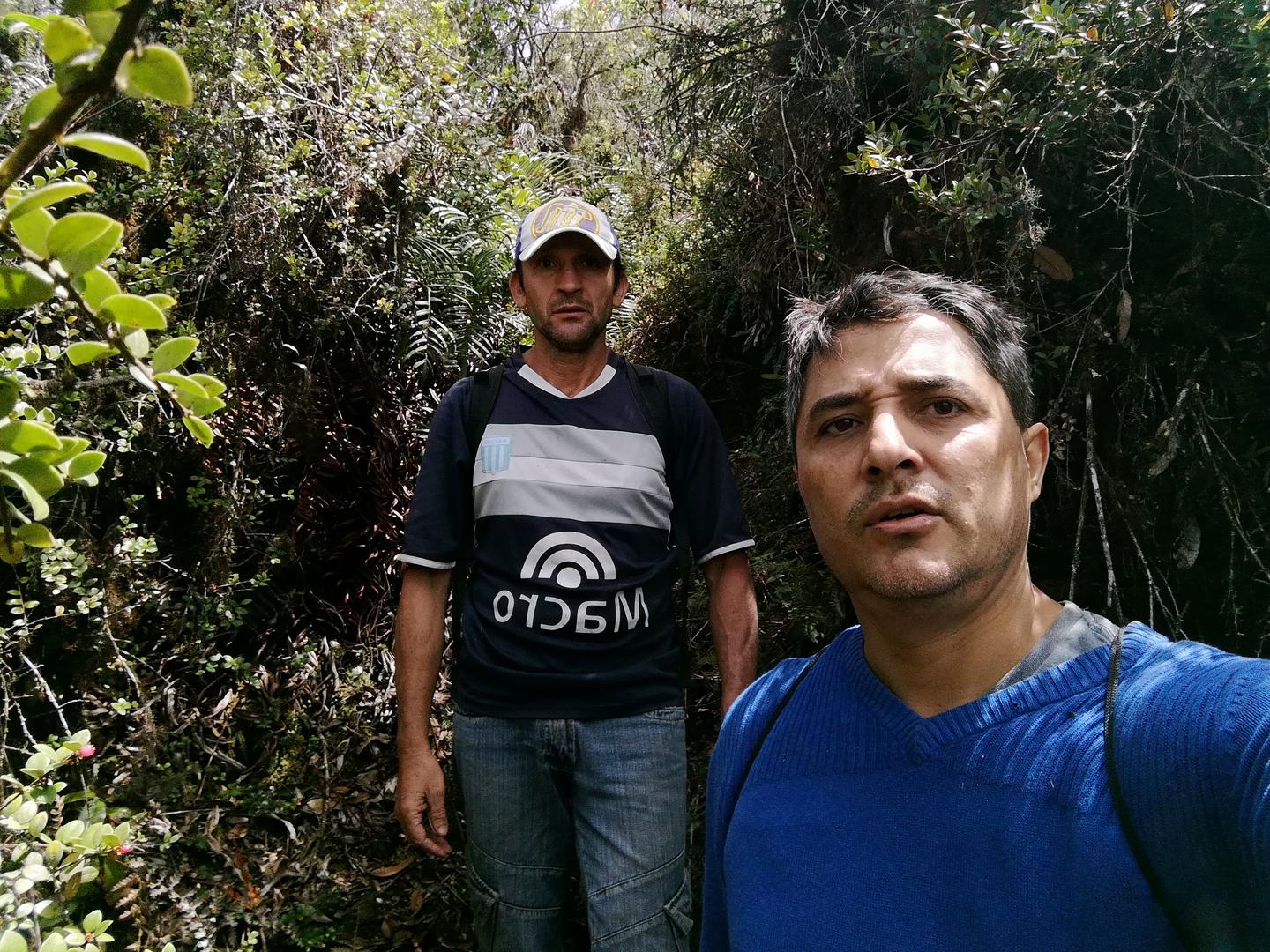 Freddy y Jairo entre la vegetación del bosque.