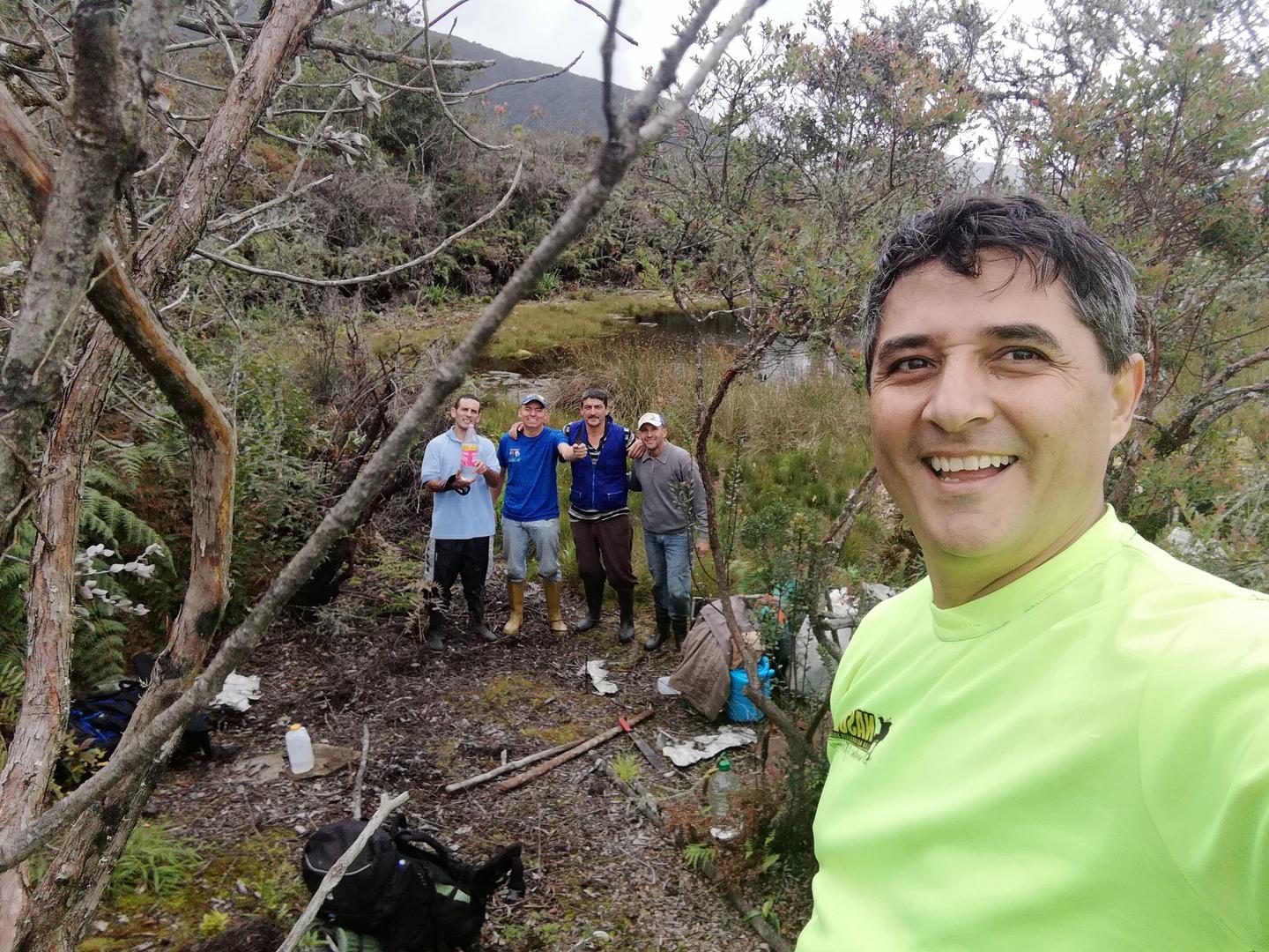 El grupo de pie entre arbustos, cerca del agua.