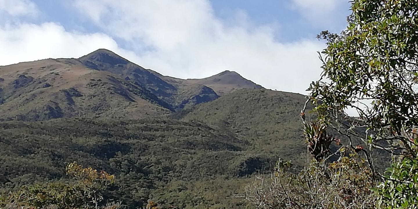 Dos cumbres de páramo bajo un cielo con nubes.