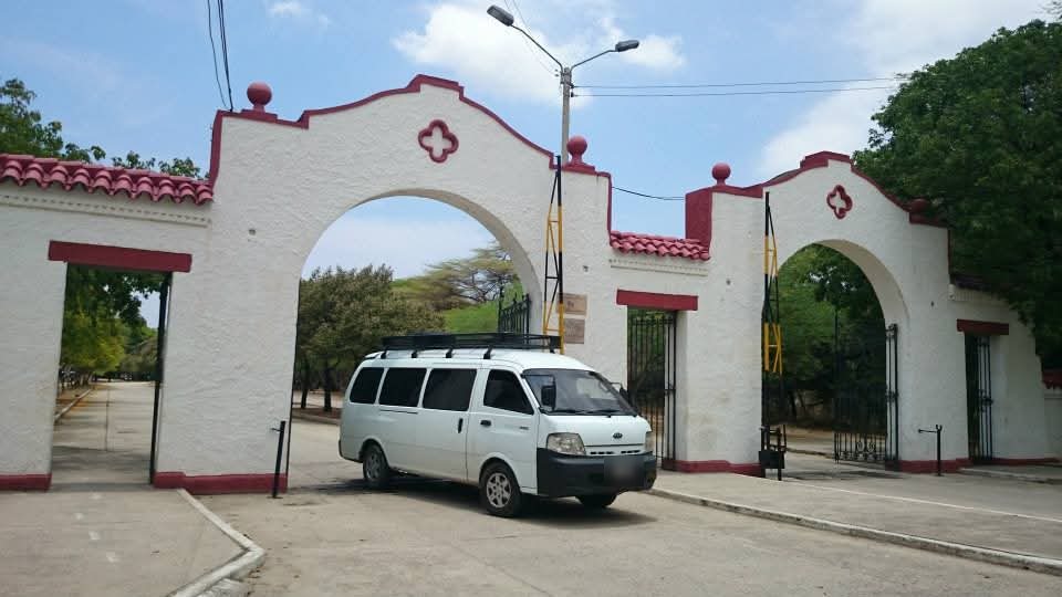 La Kia frente a un portón de arcos blancos con detalles rojos.