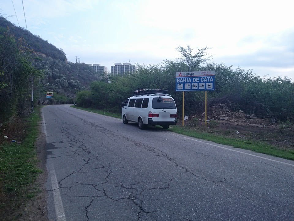 La Kia estacionada en una carretera junto al letrero de Bahía de Cata.