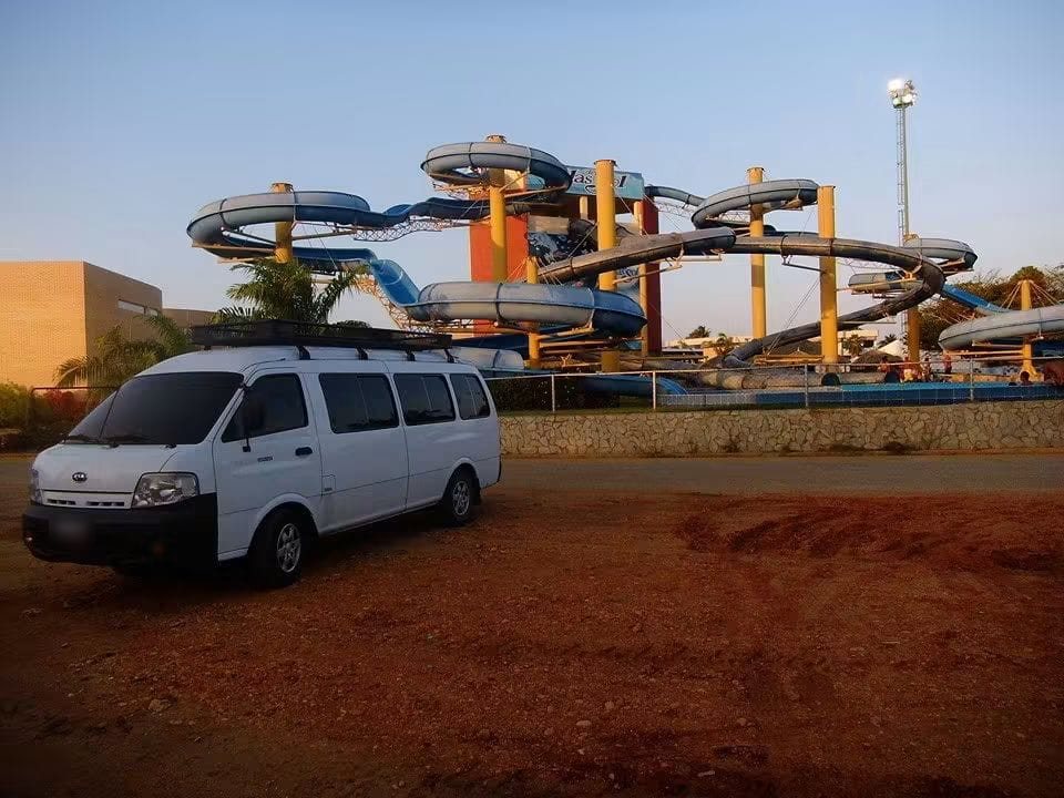 La Kia estacionada frente a los toboganes de un parque acuático.