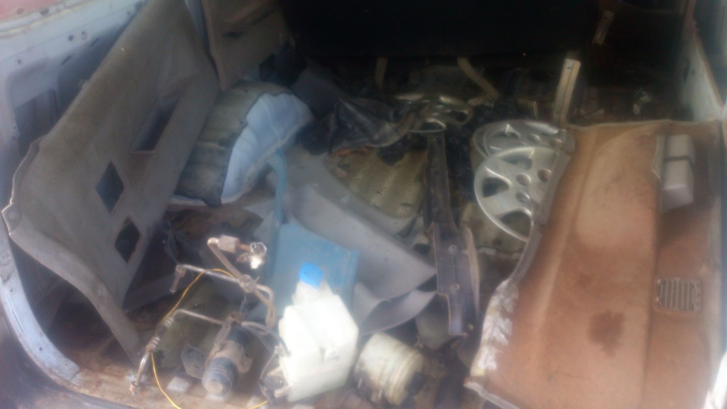 El interior de la Kia lleno de piezas sueltas, tapizado arrancado y tapacubos.